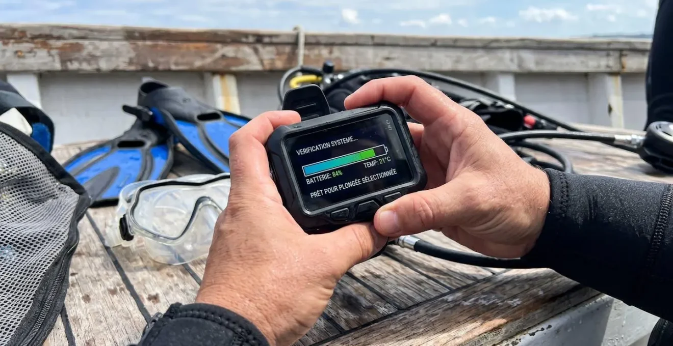 Gros plan sur un ordinateur de plongée moderne au poignet avec des gouttelettes d'eau sur le verre, écran éteint et bracelet silicone contemporain